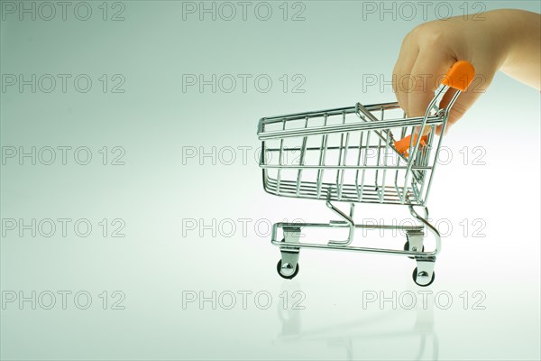 Shopping cart in the hand on white background