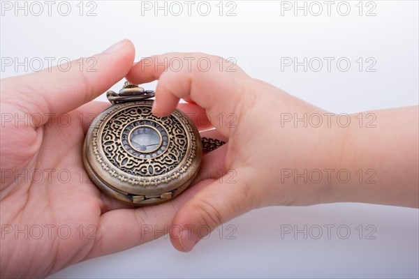 Retro style pocket watch in hand on white background