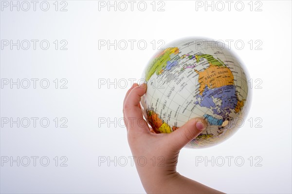 Child holding a globe in on a white background