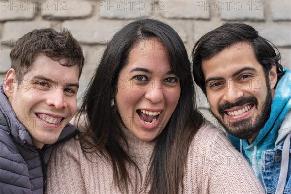 Portrait of three smiling friends looking at the camera