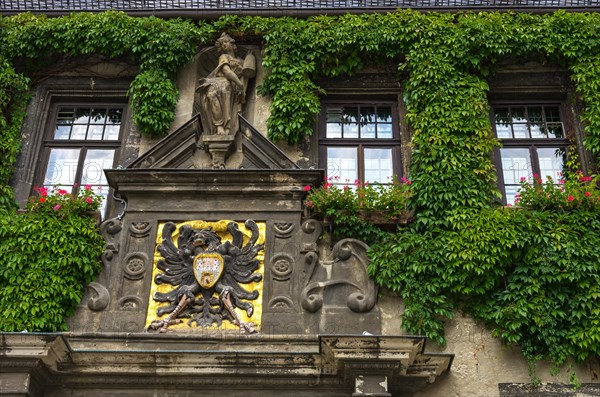 Gable with the town coat of arms above the main portal of the Gothic town hall from the beginning of the 14th century on the market square in the historic old town of the World Heritage City