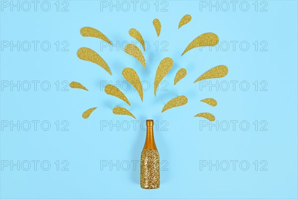 Golden splashing Champagne bottle on blue background