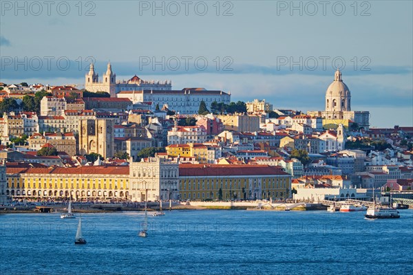 View of Lisbon Alfama district with National Pantheon and Monastery of St. Vincent over Tagus river from Almada with yachts tourist boats on sunset. Lisbon