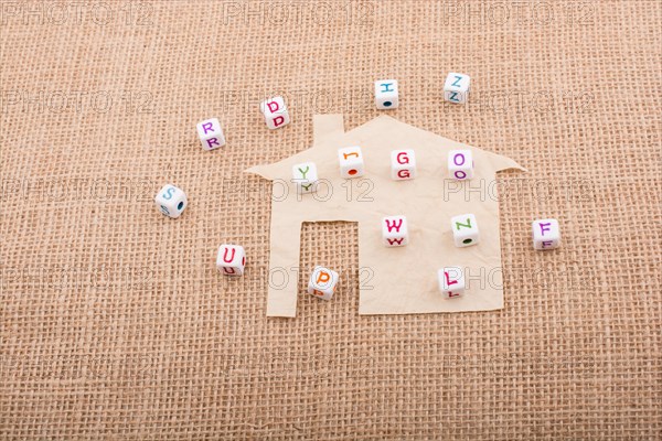 Letter cubes on house shape cut out of paper