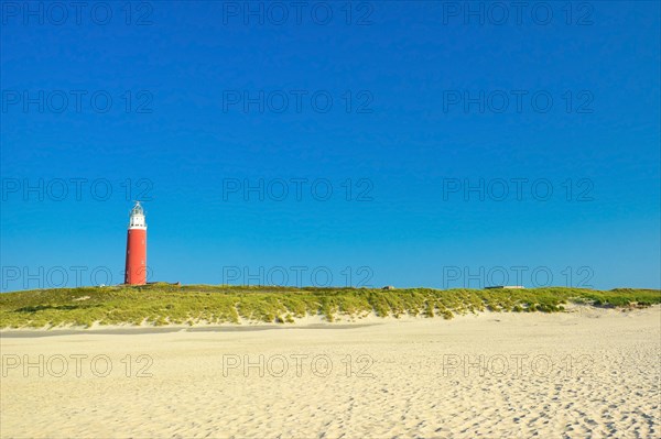 Lighthouse at northern beach of island Texel in Netherlands on summer day with blue sky