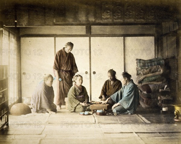 Interior view of a room in which men and woman play the board game Go