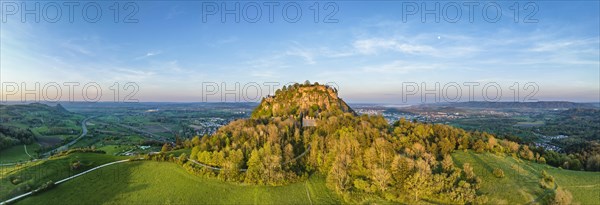 Aerial panorama of the volcanic cone Hohentwiel with the castle ruins illuminated by the evening sun