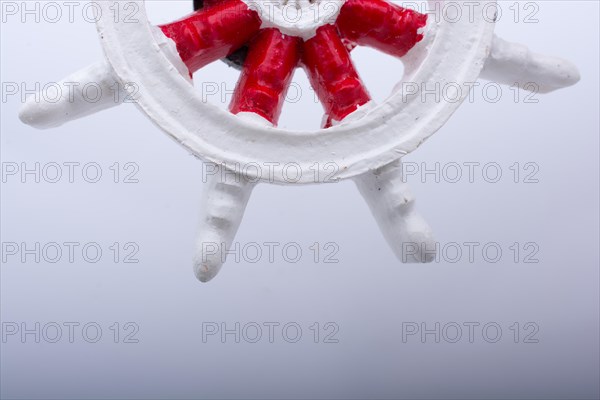 Steering wheel of a boat placed on white background