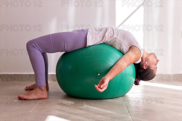 Beautiful woman training pilates on a fitness ball