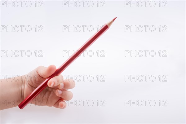 Hand holding a red color pencil on a white background