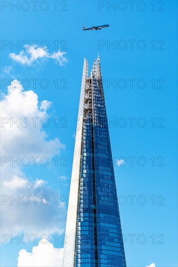 Airplane over a glass skyscraper