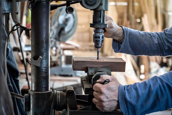 Detail of a carpenter drilling a wood with a drilling machine