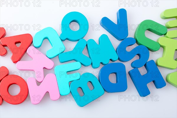 Colorful alphabet letter blocks scattered randomly on white background