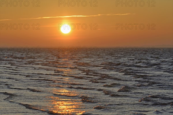 Sunrise on the beach with rising waves
