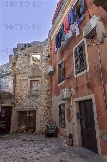 Laundry is hung out to dry on a line on an old house in an alleyway in the coastal town of Umag