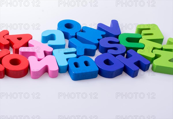 Colorful alphabet letter blocks scattered randomly on white background