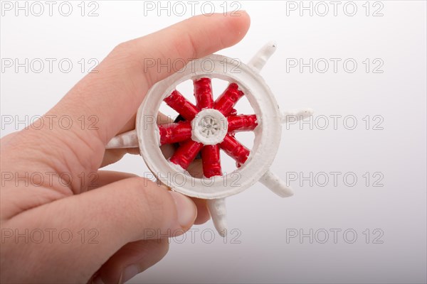 Steering wheel of a boat in hand on white background