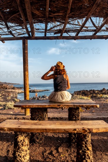 Tourist woman with her back turned at sunset on the beach of Tacoron on El Hierro