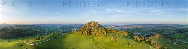 Aerial panorama of the volcanic cone Hohentwiel with the castle ruins illuminated by the evening sun