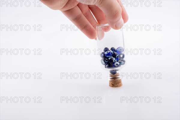 Little glass bottle with blue evil eye bead in hand