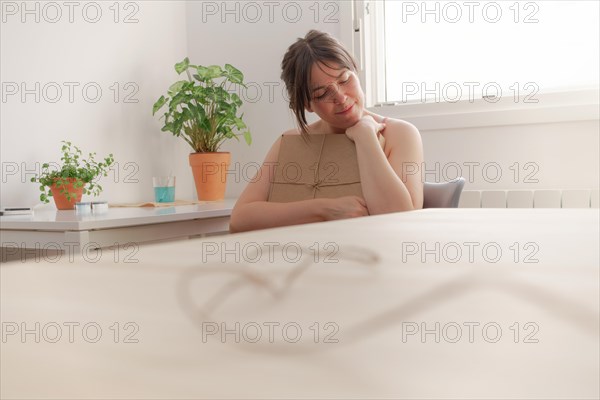 Young girl sitting on a chair hugging a gift in a cardboard box