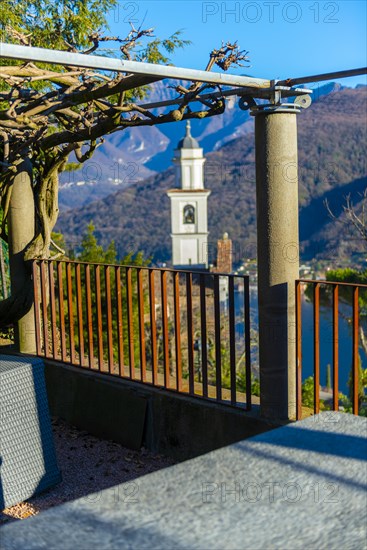 Church of Saints Fedele and Simone andRestaurant Table with Mountain in a Sunny Day in Vico Morcote