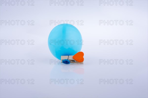 Clothespin with a heart and a balloon on white background