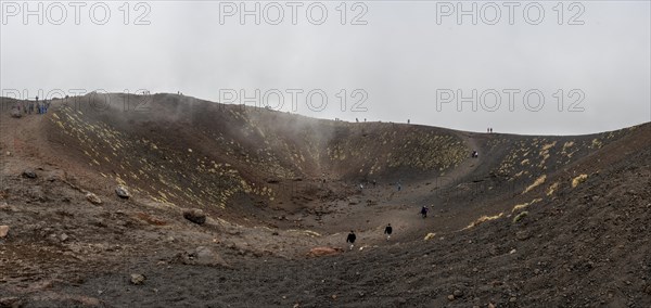 Tourists in the volcanic landscape of Etna