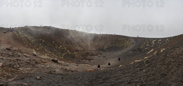 Tourists in the volcanic landscape of Etna