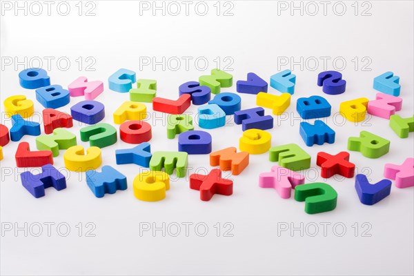 Colorful alphabet letter blocks scattered randomly on white background