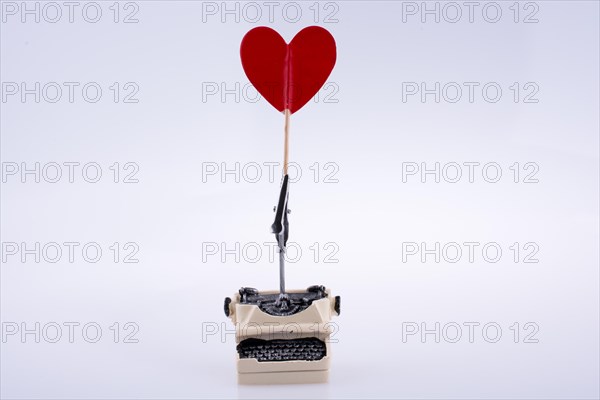 Heart shape icon on a typewriter on white background