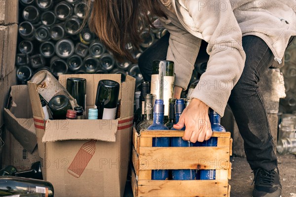 Unrecognizable woman hand holding wooden box with glass materials for recycling