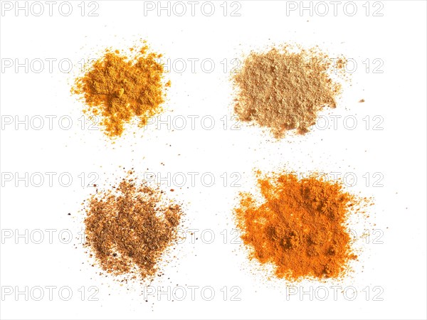 Many spices including Ginger Curry Turmeric and Chili Pepper over white