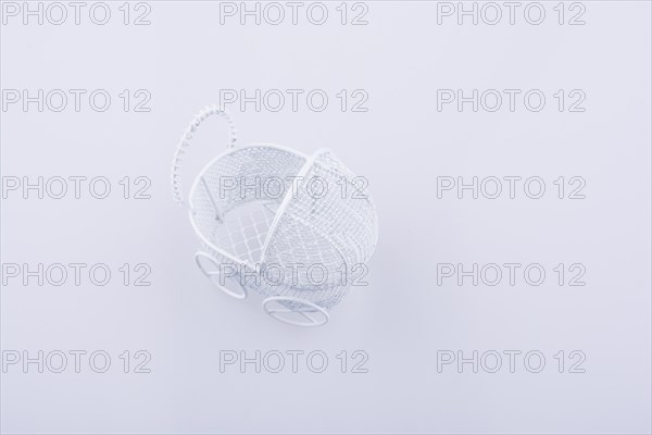 Toy baby carriage made of metal on white background