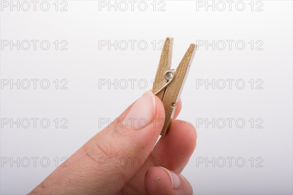 Hand holding a small wooden clothespin in hand