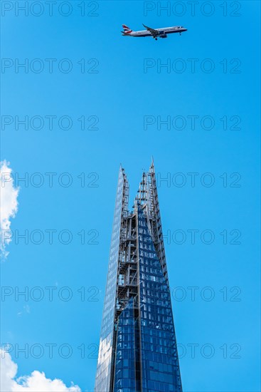 Airplane over a glass skyscraper