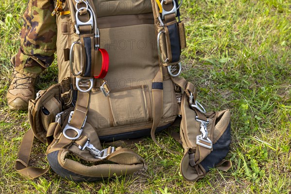 Military Parachuter Standing on the Grass with His Parachute in Switzerland