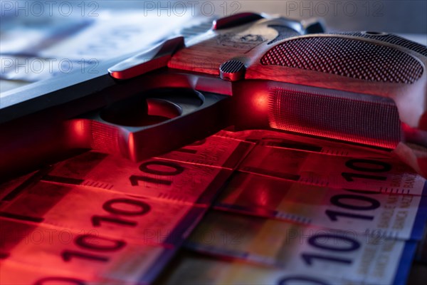 Elegant Semiautomatic 9mm Handgun with Swiss Helvetia Symbol Leaning on Swiss Franc 1000 Banknote in Switzerland