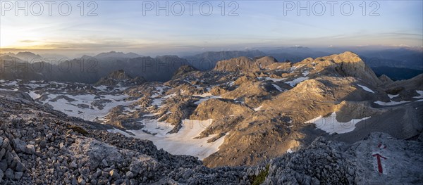 View of rocky plateau with glacier and remnants of snow in the evening light