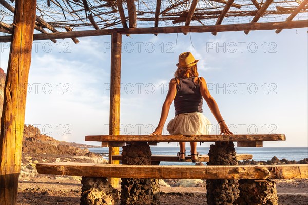 Tourist woman at sunset on Tacoron beach on El Hierro