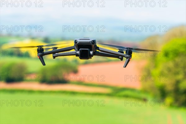 Drone in flight over fields and farms