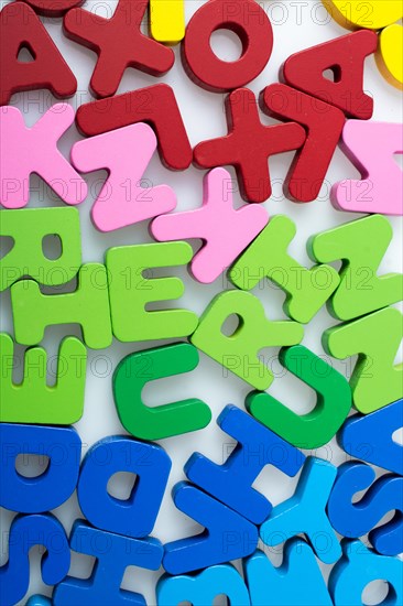 Colorful alphabet letter blocks scattered randomly on white background