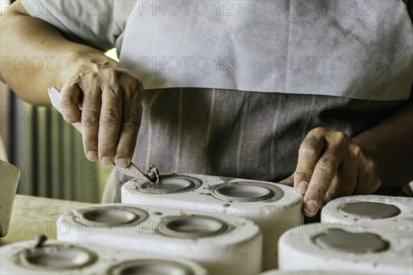 Potter working in her art studio. Ceramic creation process. Master potter working in her studio