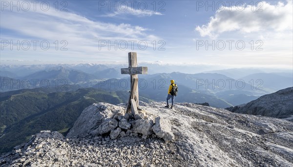 Mountaineer at a secondary peak of the Hochkoenig with summit cross
