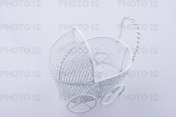 Toy baby carriage made of metal on white background