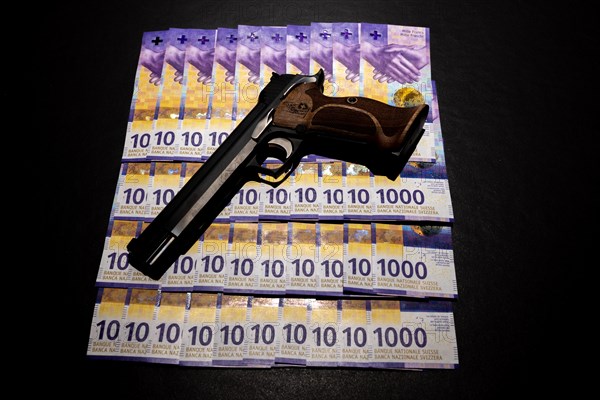 Elegant Semiautomatic 9mm Handgun with Swiss Helvetia Symbol Leaning on Swiss Franc 1000 Banknote in Switzerland