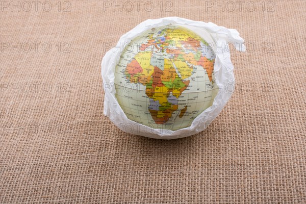 Globe wrapped with paper placed on canvas background