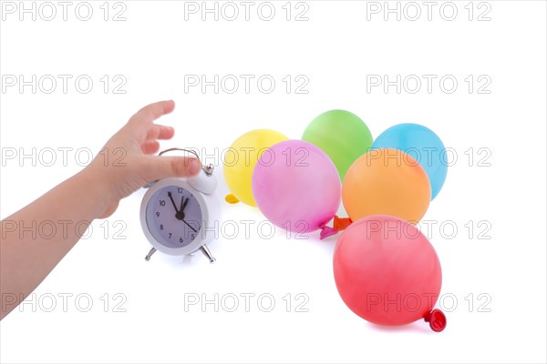 Hand holding an alarm clock with balloons on the white background