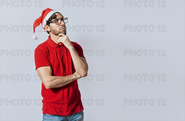 Thoughtful christmas man looking aside. Christmas handsome guy with thoughtful face isolated. Thoughtful man in christmas clothes with hand on chin. Thoughtful christmas man concept