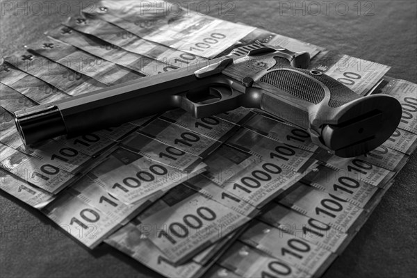 Elegant Semiautomatic 9mm Handgun with Swiss Helvetia Symbol Leaning on Swiss Franc 1000 Banknote in Switzerland